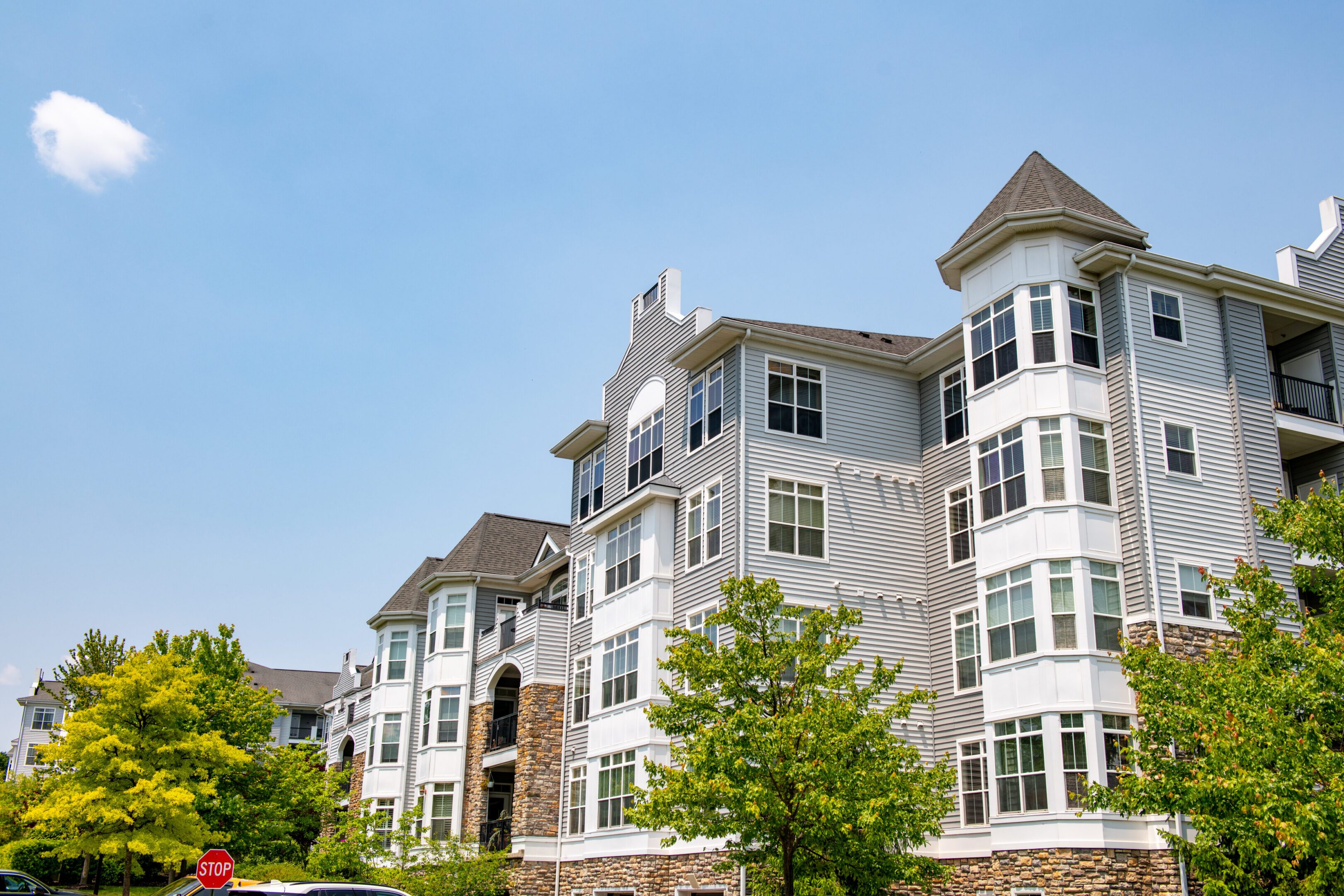 Modern white apartment buildings under a clear blue sky.