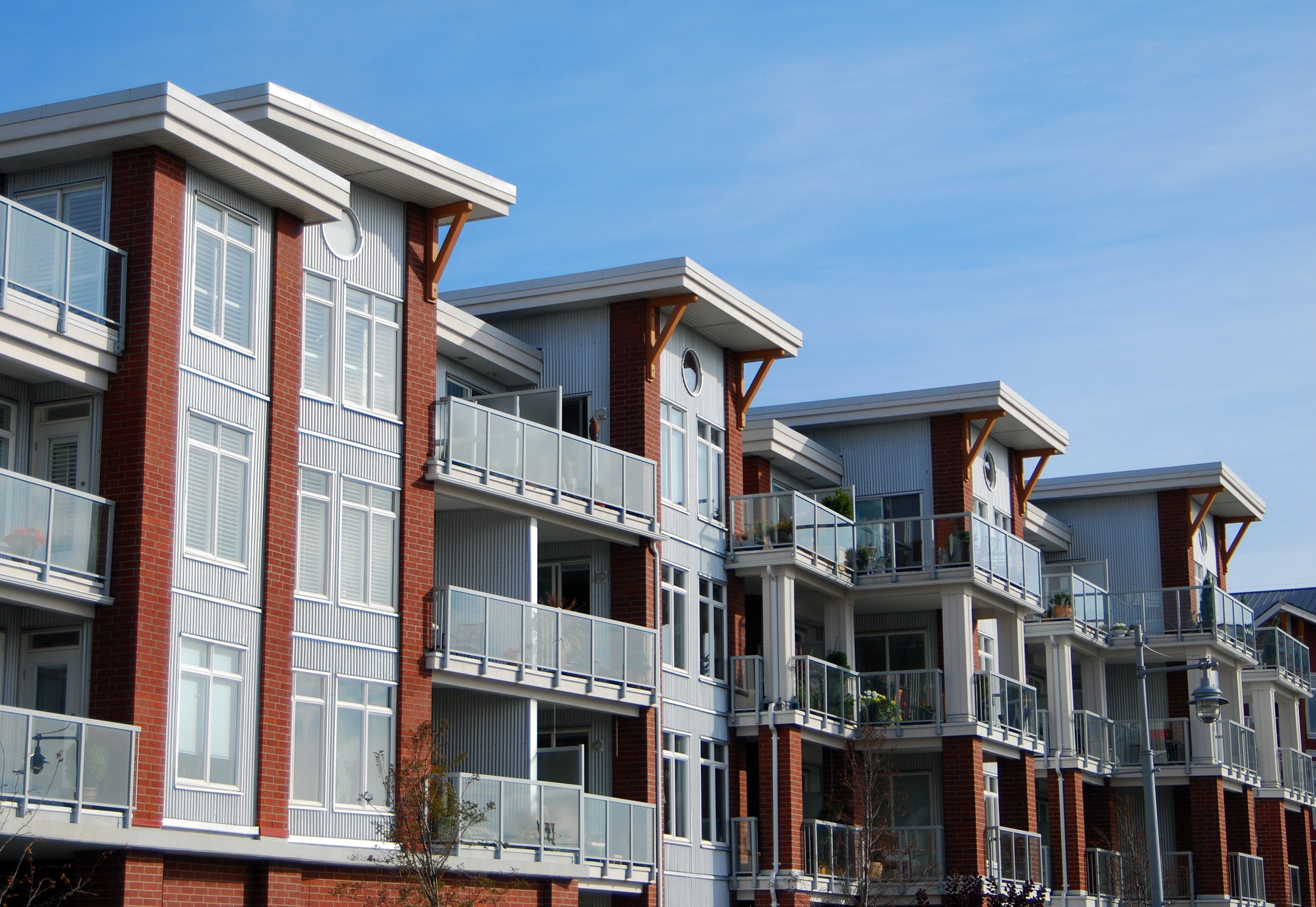 Modern apartment building with balconies under a clear blue sky.
